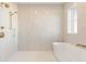 This bathroom has a standing shower, a window, a bathtub, and bronze shower fixtures at 260 Guild Ln, Fayetteville, GA 30214