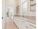 Bright butler's pantry with stone countertops, shelving, stainless faucet, and ample white cabinets at 260 Guild Ln, Fayetteville, GA 30214