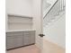Hallway with gray cabinets and drawers, and a staircase with black wrought iron railing in the background at 260 Guild Ln, Fayetteville, GA 30214