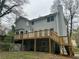 Backyard view featuring a spacious wooden deck with stairs and grey siding at 4481 Dunmovin Nw Dr, Kennesaw, GA 30144
