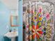 Cozy bathroom featuring a pedestal sink, framed mirror, and colorful patterned shower curtain at 53 Weatherstone Pkwy, Marietta, GA 30068