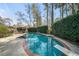 Backyard pool area featuring a diving board, hot tub, seating area, and privacy bushes at 53 Weatherstone Pkwy, Marietta, GA 30068