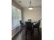 Cozy breakfast nook with modern lighting, large windows, and a dark wood table with leather chairs at 5915 Windsorcreek Dr, Douglasville, GA 30135
