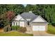 Charming single-Gathering home featuring a brick facade and a manicured lawn, complemented by mature trees at 5915 Windsorcreek Dr, Douglasville, GA 30135