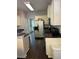 Galley style kitchen with stainless steel appliances, white cabinets, and dark countertops and flooring at 5915 Windsorcreek Dr, Douglasville, GA 30135