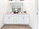 Bathroom featuring a large mirror above a double vanity with white cabinets and neutral countertop at 2029 Memorial Dr # 32, Atlanta, GA 30317