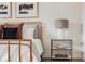 Close-up of a nightstand with a modern lamp, decor, and a bed with pillows at 2029 Memorial Dr # 32, Atlanta, GA 30317