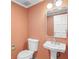 Stylish half bathroom features a pedestal sink, a mirror, and peach colored textured walls at 2769 Peachtree Ne Rd # 10, Atlanta, GA 30305