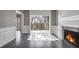 Living room featuring a fireplace, balcony access, and wainscotting, with natural light and outdoor views at 2769 Peachtree Ne Rd # 10, Atlanta, GA 30305