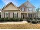 Charming two-story home featuring a mix of brick and stone accents, complemented by lush landscaping and a welcoming entrance at 3305 Pleasant Manor Ct, Cumming, GA 30028