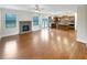 Open living room with hardwood floors, stone fireplace, and view into the kitchen at 3305 Pleasant Manor Ct, Cumming, GA 30028