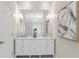 Bright bathroom with a double vanity, marble countertop, decorative mirror, and modern sconces at 3895 Overlake Dr, Cumming, GA 30041