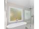 Modern bathroom featuring a freestanding tub and a glass-enclosed shower with white marble tiling at 3895 Overlake Dr, Cumming, GA 30041