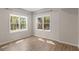 Neutral bedroom featuring wood-look floors and two large windows bringing in natural light at 3895 Overlake Dr, Cumming, GA 30041