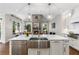 Open kitchen with white cabinets, stainless steel appliances, and fireplace, flowing into the living area at 3895 Overlake Dr, Cumming, GA 30041