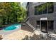 Modern home featuring a pool, exterior staircase, and stone patio at 4 W Wesley Nw Rdg, Atlanta, GA 30327