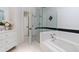 Contemporary bathroom includes a soaking tub, glass shower, and elegant white finishes at 4 W Wesley Nw Rdg, Atlanta, GA 30327