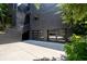 Modern house featuring sleek glass garage doors and textured black facade at 4 W Wesley Nw Rdg, Atlanta, GA 30327