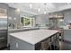 Spacious kitchen with gray cabinetry, large island, stainless steel appliances, and tile backsplash at 4 W Wesley Nw Rdg, Atlanta, GA 30327