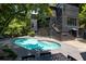 Stunning modern black house exterior with a spacious kidney-shaped pool and surrounding trees at 4 W Wesley Nw Rdg, Atlanta, GA 30327