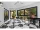 Bright sun room with black and white tiled floor, views of the backyard, and a piano at 4 W Wesley Nw Rdg, Atlanta, GA 30327