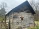 Exterior view of rustic barn with a metal star and gate, adding character and charm to the property at 905 Attaway Rd, Bowdon, GA 30108