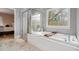 Bright bathroom featuring a soaking tub, separate shower, and marble tile at 905 Attaway Rd, Bowdon, GA 30108