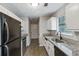 Galley style Kitchen featuring granite countertops, black appliances and white cabinets at 164 Adrian Dr, Stockbridge, GA 30281