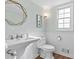 Charming powder room with pedestal sink, decorative mirror, and stylish white tile work at 2480 Roxburgh Dr, Roswell, GA 30076