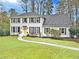 Charming two-story white brick home with black shutters and a well-manicured front lawn at 2480 Roxburgh Dr, Roswell, GA 30076