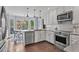 Modern kitchen featuring white cabinets, stainless steel appliances, and a sunlit breakfast nook at 2480 Roxburgh Dr, Roswell, GA 30076