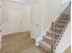 Bright entryway with wood-look flooring and a staircase featuring a wood handrail and black iron balusters at 28 Kensington St, Kingston, GA 30145