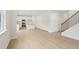 Bright living room with wood-look flooring, an open-concept kitchen, and a staircase with wood and iron details at 28 Kensington St, Kingston, GA 30145