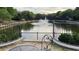Relaxing pond view with fountain, foliage and metal bridge in the distance from a comfortable patio set at 390 17Th Nw St # 4037, Atlanta, GA 30363