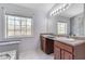 Bathroom featuring dual vanities, a large mirror, and a soaking tub with tile floors at 5 Burns View Ct, Lawrenceville, GA 30044