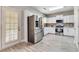 White kitchen with stainless-steel appliances and fixtures plus wood look tile floors at 5 Burns View Ct, Lawrenceville, GA 30044