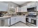 Modern kitchen featuring stainless steel appliances, white cabinetry, tile backsplash, and a stainless sink at 5 Burns View Ct, Lawrenceville, GA 30044
