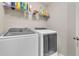 Functional laundry area equipped with modern washer and dryer units, and storage shelves at 5 Burns View Ct, Lawrenceville, GA 30044