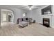 Living room featuring a fireplace, ceiling fan, wood floors, and modern sectional couch at 5 Burns View Ct, Lawrenceville, GA 30044