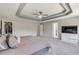 Spacious main bedroom with a ceiling fan, tray ceiling, walk-in closet, and adjacent bathroom at 5 Burns View Ct, Lawrenceville, GA 30044