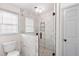 Bathroom featuring a marble tiled glass shower enclosure with a river rock floor, and a nearby toilet at 906 John Ct, Lawrenceville, GA 30046
