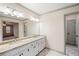 Bright bathroom with granite countertop vanity, dual sinks, and a view into the Primary bedroom at 906 John Ct, Lawrenceville, GA 30046