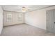 Spacious bedroom featuring neutral carpeting, two windows for natural light, and a ceiling fan at 906 John Ct, Lawrenceville, GA 30046