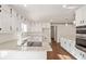 Modern kitchen features white cabinets, granite countertops, and stainless steel appliances at 906 John Ct, Lawrenceville, GA 30046