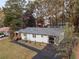 Aerial view of a renovated home with new roof, dark driveway and lush surrounding trees at 1970 Capri Dr, Decatur, GA 30032