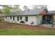 Back exterior view of a freshly painted white brick home with a modern outdoor living space at 1970 Capri Dr, Decatur, GA 30032