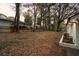 Spacious yard with mature trees bordering the freshly painted white brick home at 1970 Capri Dr, Decatur, GA 30032
