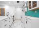 Bright kitchen featuring white cabinets, marble floors, stainless steel dishwasher, and a turquoise backsplash at 1970 Capri Dr, Decatur, GA 30032