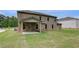 Large backyard featuring a covered patio and healthy lawn with a brick home at 205 Haverling Pass, Hampton, GA 30228