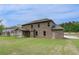 Large brick home featuring a sprawling backyard with ample green space at 205 Haverling Pass, Hampton, GA 30228